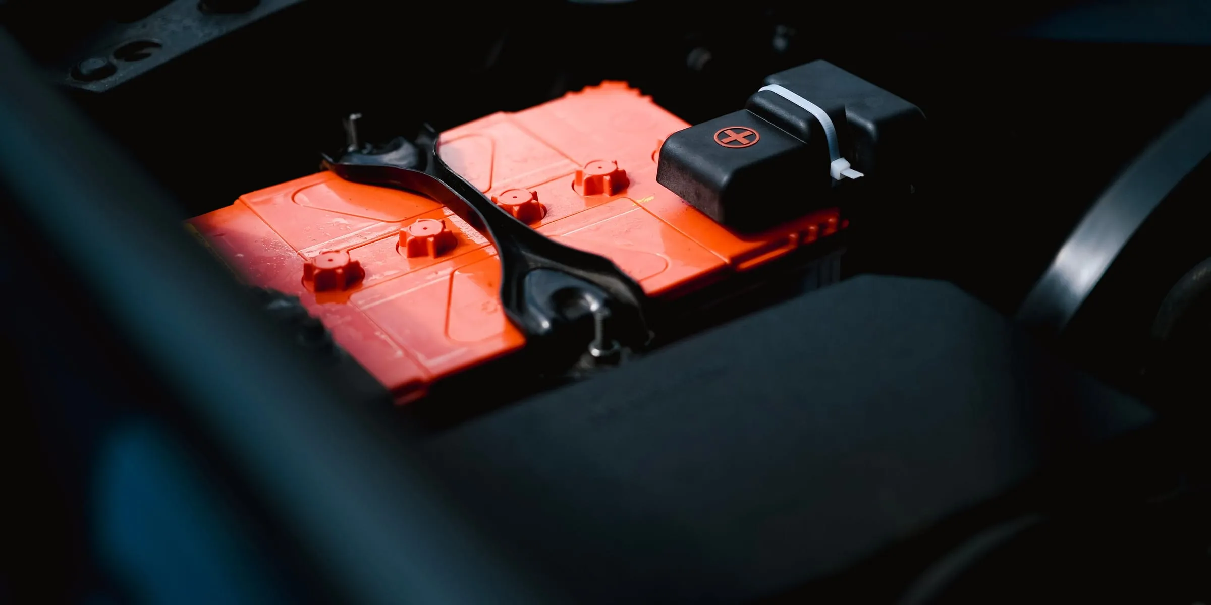 An orange battery module in a dark equipment bay